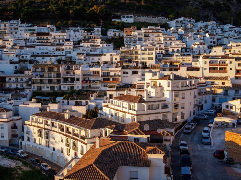 'Whitewashed houses of Mijas Pueblo on the hillside, seen from the south in evening light'